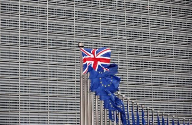 File photo of a Union Jack flag fluttering next to European Union flags ahead of a visit from Britain's Prime Minister David Cameron at the EU Commission headquarters in Brussels